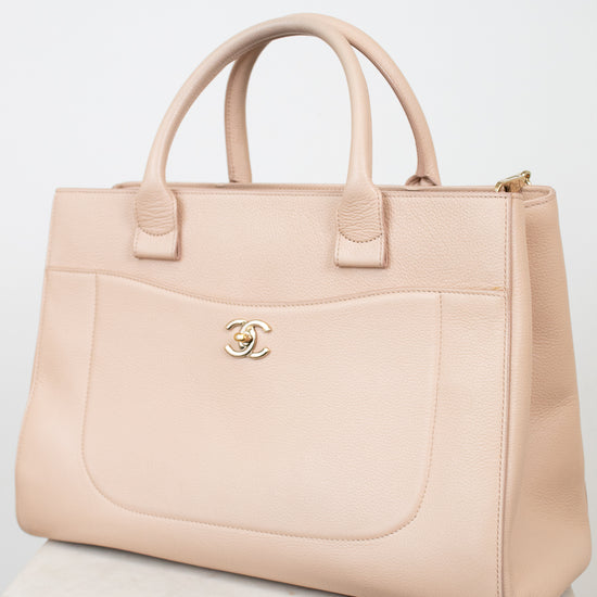 Beige handbag with Chanel logo on a white background