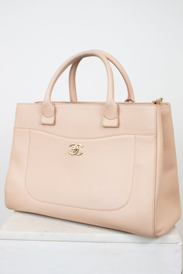 Beige handbag with Chanel logo on a white background