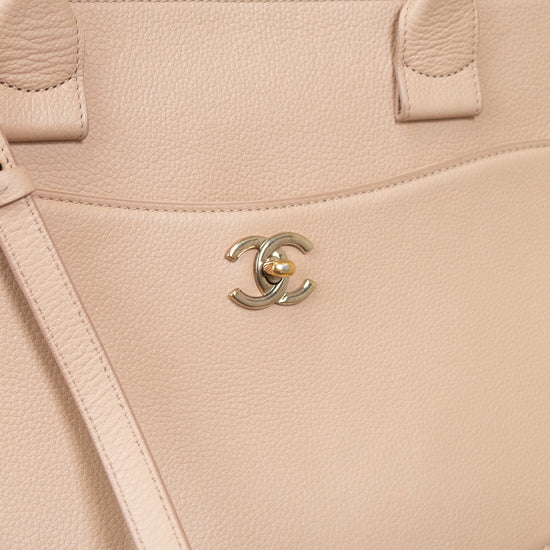 Beige handbag with Chanel logo on a light background