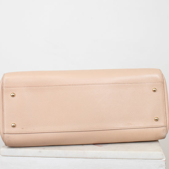Beige handbag on a white surface with a white background