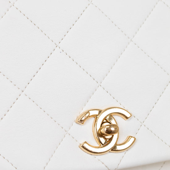White quilted handbag with gold CC logo on a light gray background