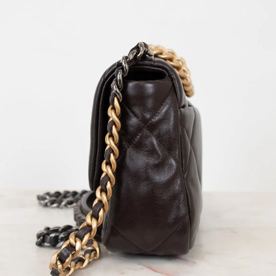 Brown leather handbag with gold chain strap on a white background