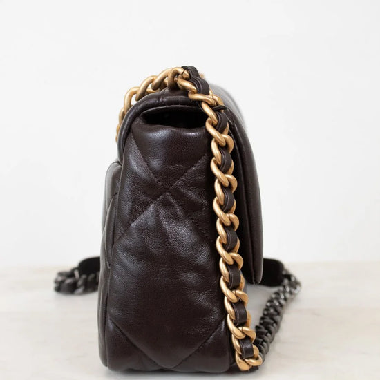 Brown quilted handbag with gold chain strap on a white background