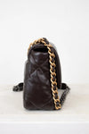 Brown quilted handbag with gold chain strap on a white background