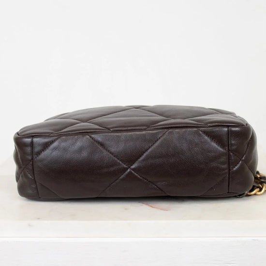 Brown quilted handbag on a light gray background