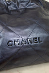 Close-up of a quilted navy leather Chanel handbag.
