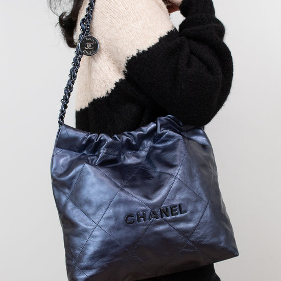 Person holding a Chanel handbag against a plain background
