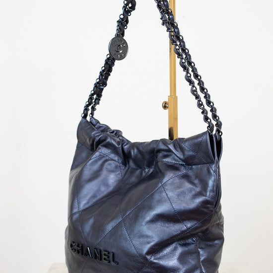 Chanel navy handbag with chain detail on a white background