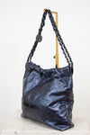 Chanel navy handbag with chain detail on a white background