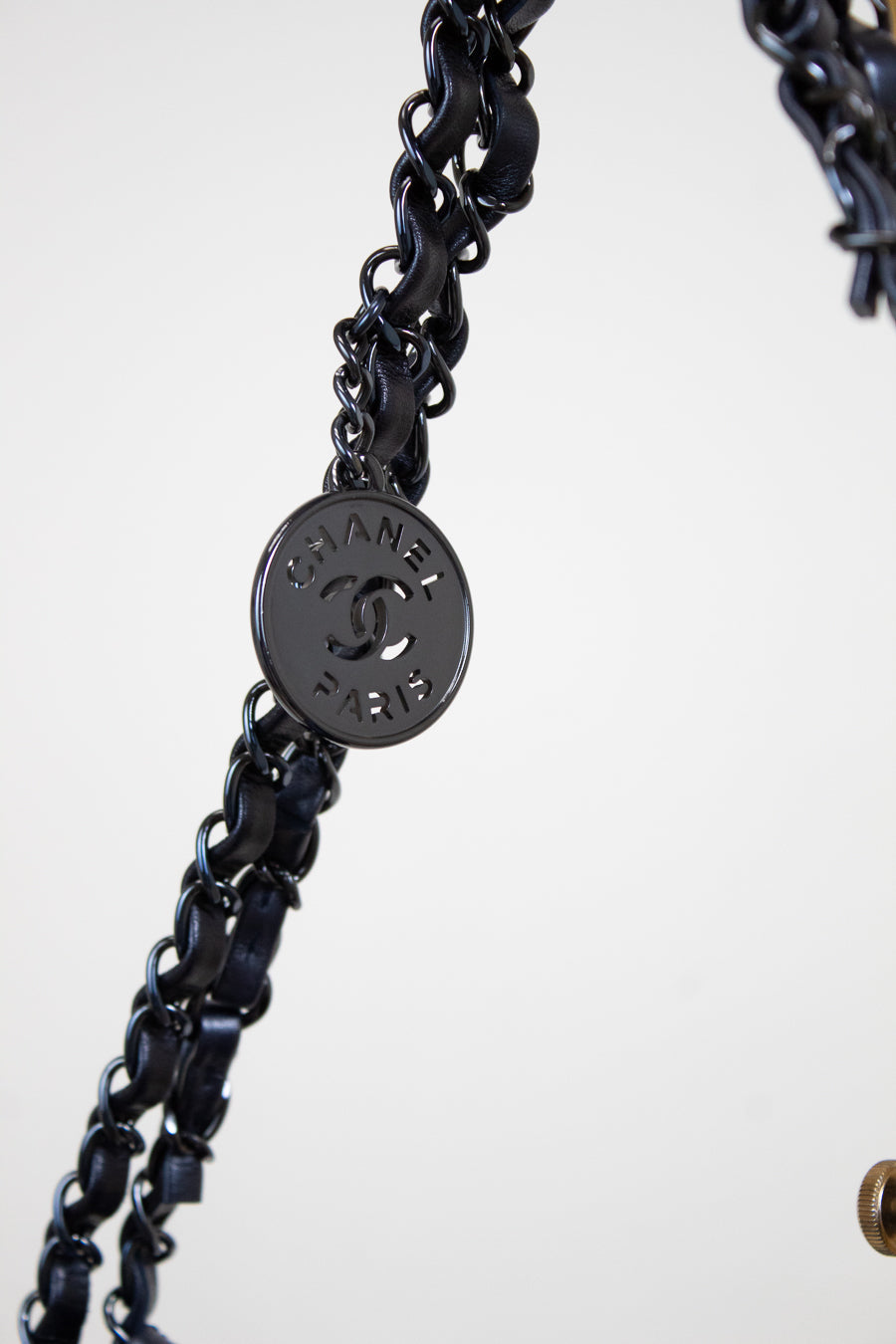 Navy chain with a Chanel logo tag on a white background