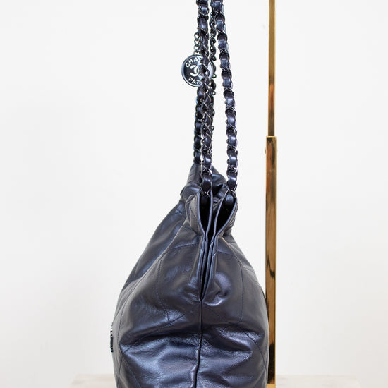 Navy leather handbag with chain handle on a white background