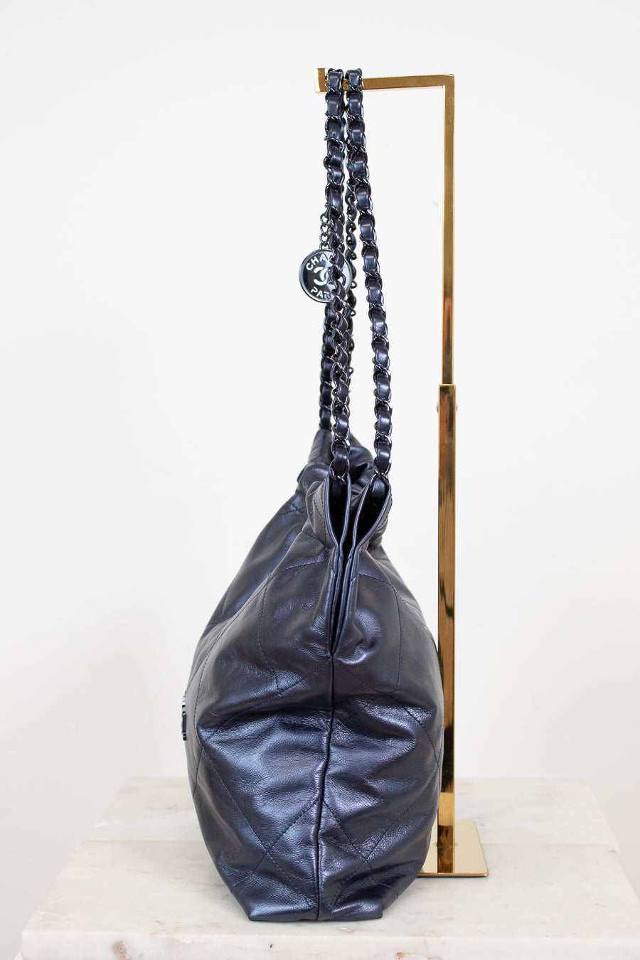 Navy leather handbag with chain handle on a white background