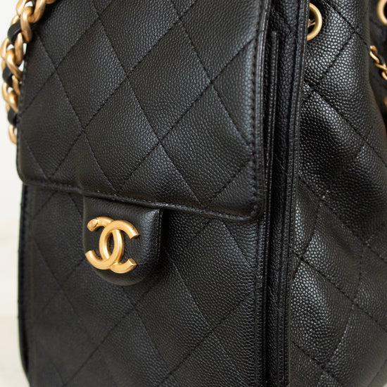 Black quilted handbag with gold chain and CC logo on a light background