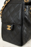 Black quilted handbag with gold chain and CC logo on a light background