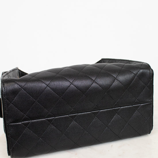 Black quilted handbag on a white marble surface