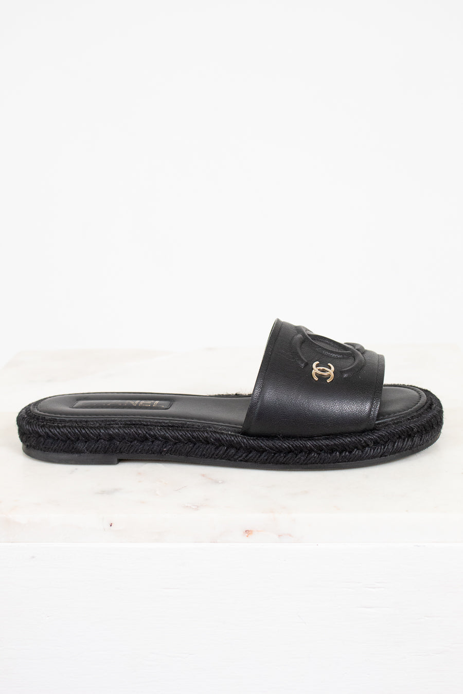 Black sandal with a brand logo on a white background