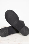 Black rubber sandals with Chanel logo on a light background