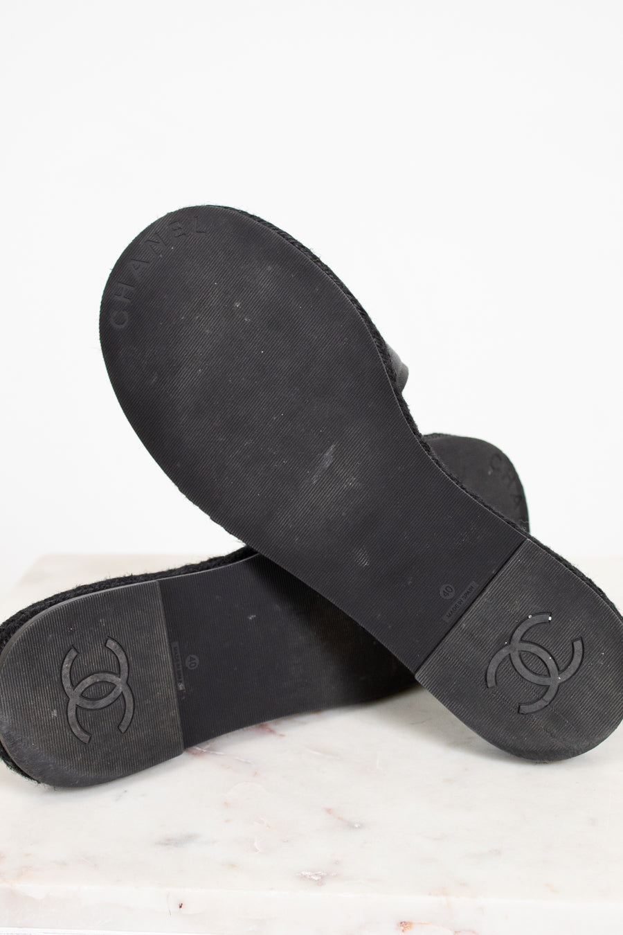 Black rubber sandals with Chanel logo on a light background