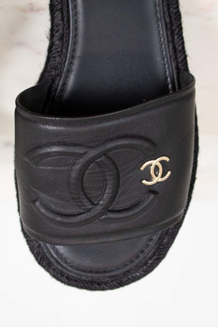 Black Chanel sandal with logo on a light background