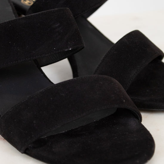 Black suede sandals on a white background