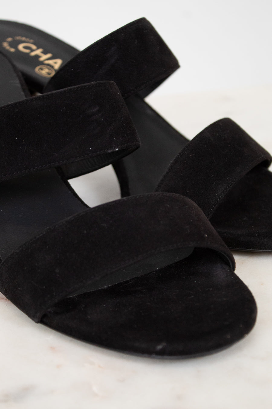 Black suede sandals on a white background
