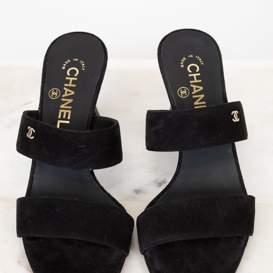 Pair of black Chanel sandals on a white background