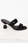 Black sandal with a high heel and pearl detail on a white background