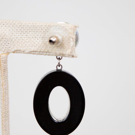 Back of black circular earring on a white background