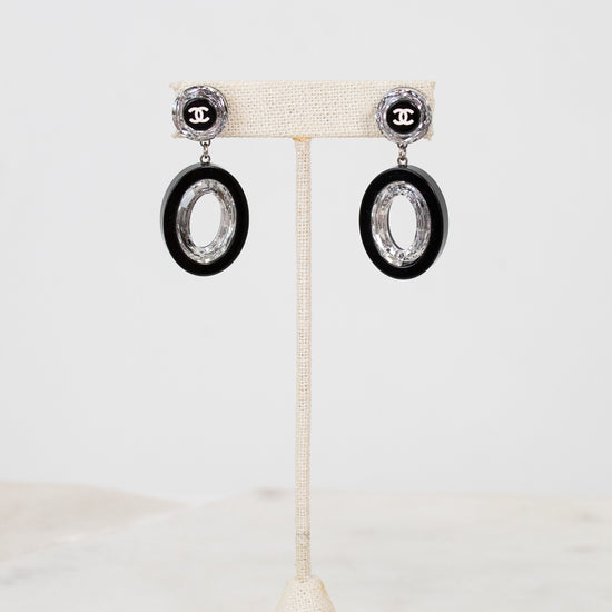 Pair of earrings on a white stand with a light background