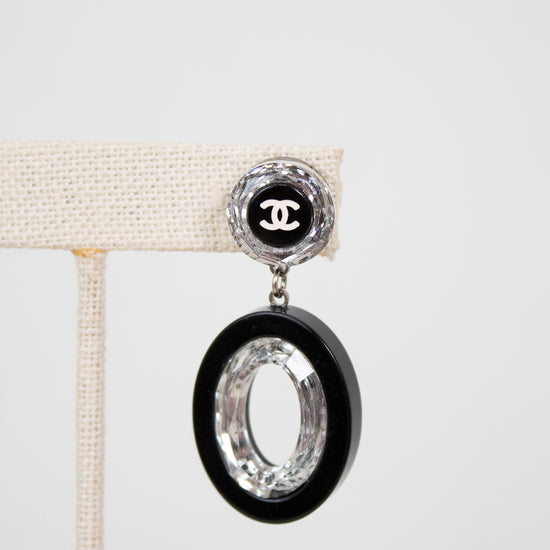 Chanel earring with black and silver design on a white background