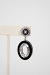 Chanel earring with black and silver design on a white background