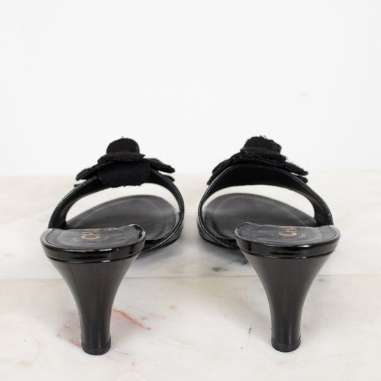 Pair of black kitten heels on a light marble surface