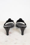 Pair of black kitten heels on a light marble surface