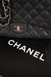 Close-up of a black quilted Chanel handbag with the brand logo.
