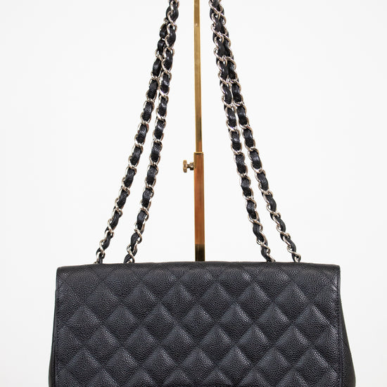 Black quilted handbag with chain strap on a white background