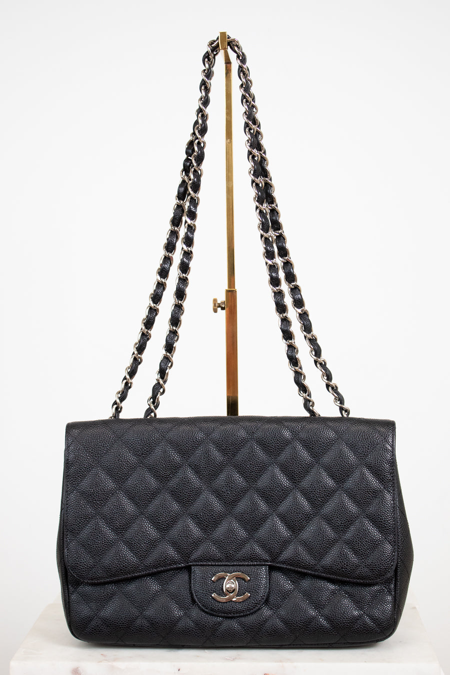 Black quilted handbag with chain strap on a white background