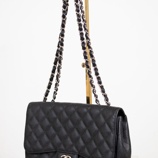Black quilted handbag with chain strap on a white background