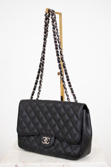 Black quilted handbag with chain strap on a white background