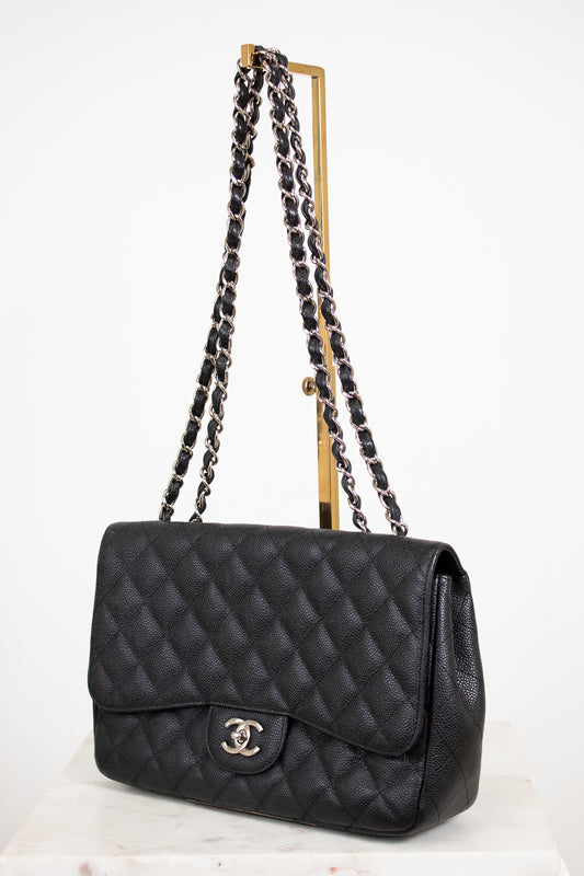 Black quilted handbag with chain strap on a white background