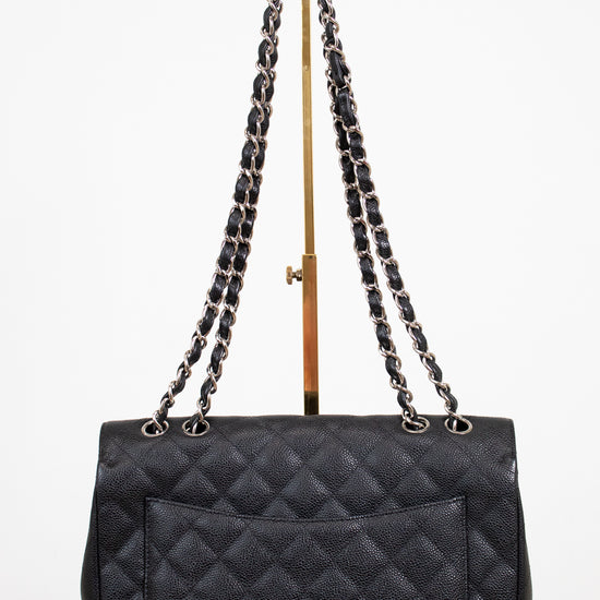 Black quilted handbag with chain strap on a white background