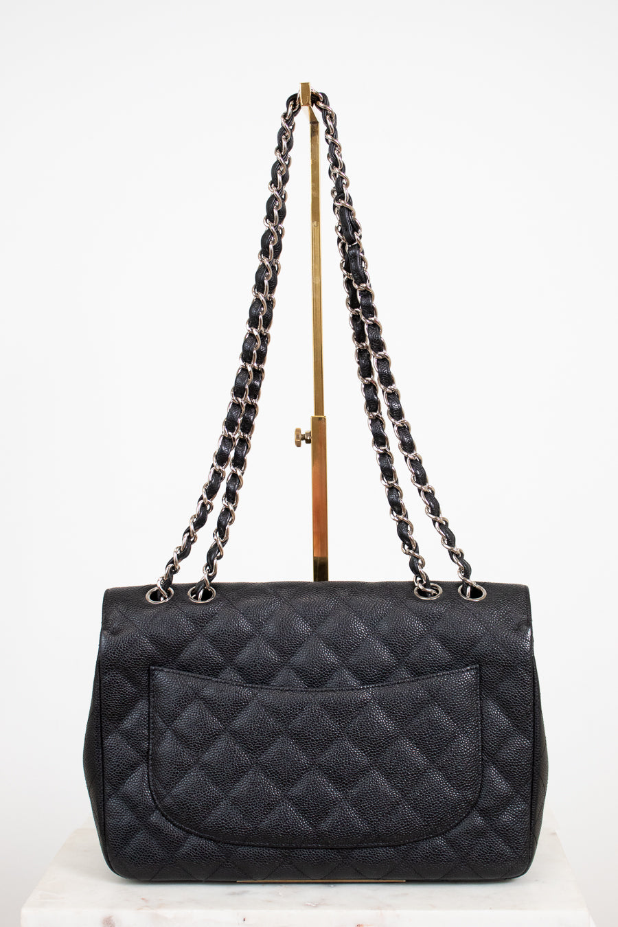 Black quilted handbag with chain strap on a white background