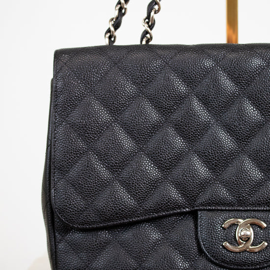 Black quilted Chanel handbag on a white background
