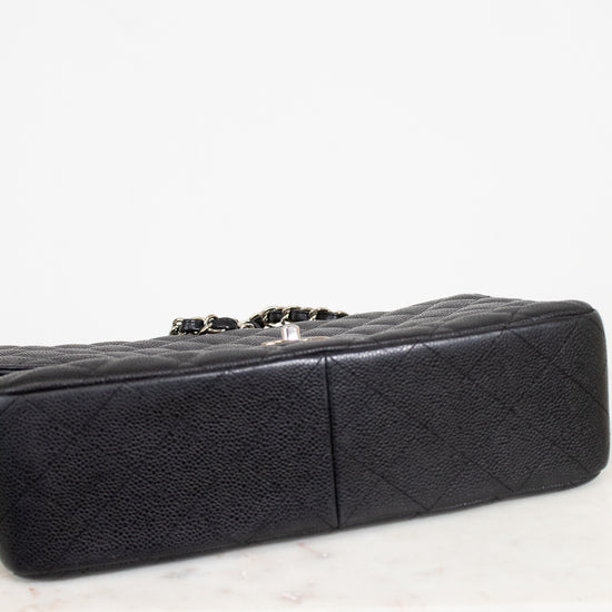 Black quilted handbag on a light gray background