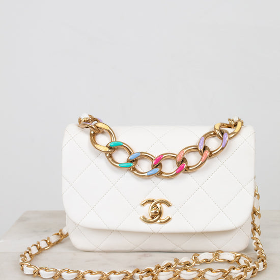White Chanel handbag with gold chain on a light gray background