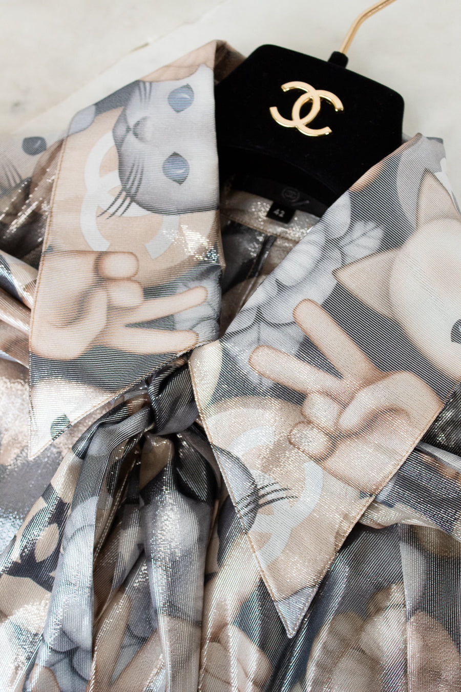 Close up of Chanel blouse collar with mixed cat pattern on black hanger with Chanel logo