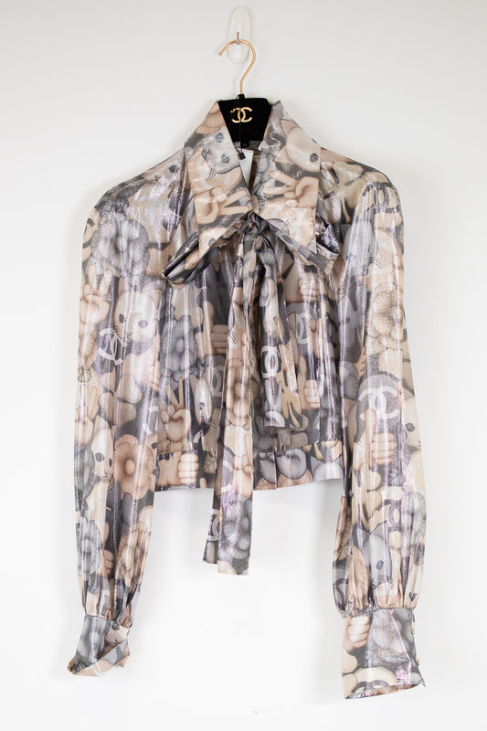 Patterned blouse on a hanger against a white background