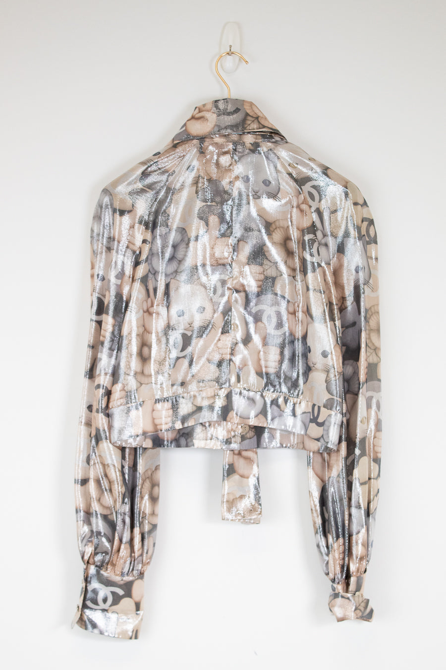 Cat and emoji print blouse hanging on a white wall