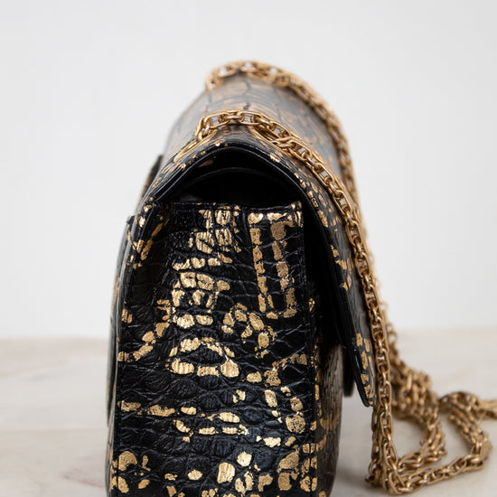 Black handbag with gold chain strap on a white background