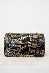 Black handbag with gold geometric pattern on a white background