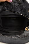 Black interior of a gray textured back being held open